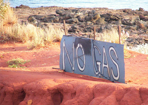 A corrugated iron sign reads no gas. It is on stakes in the ground.