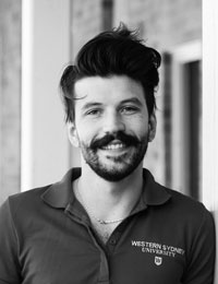 black and white portrait photograph of a man with a beard