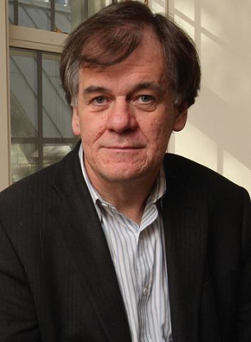Shoulder-up image of Tim Mitchell wearing a white collared shirt and black jacket