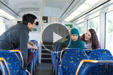 Video - Play button over picture of train passengers being racist towards a Muslim women.
