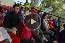Video - Play button over picture of sports fans sitting in stadium seats