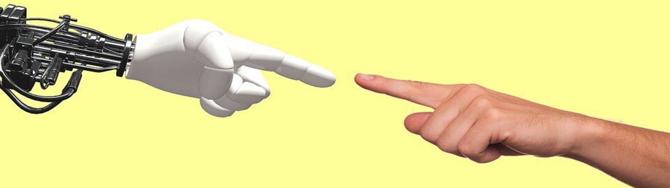image of a robot hand reaching towards a human hand 