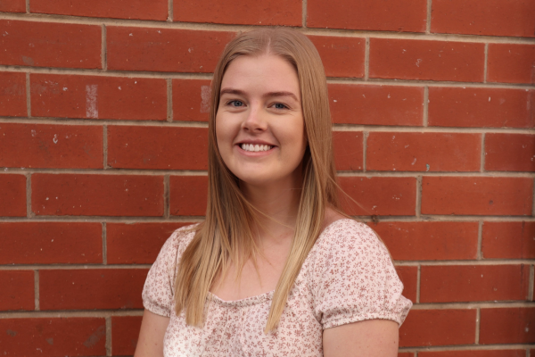Dr Amelia Mardon standing in front of a brick wall