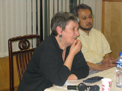 Jeannie Martin sitting at a table, presenting a paper.