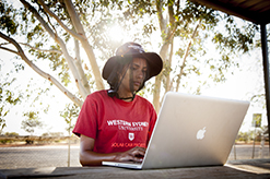 Student looking at computer in the outback