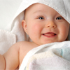 Smiling baby warped in white blanket