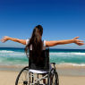 summer vacation: woman in wheelchair enjoying outdoors beach