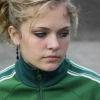 A teenage girl looks away from the camera with a sad expression