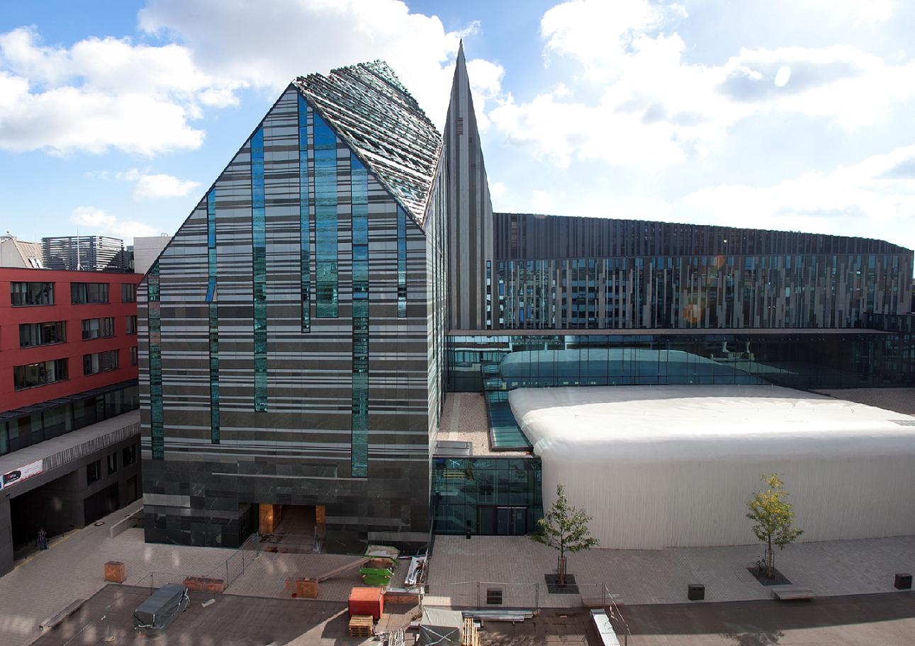 futuristic building with glass panels against a blue sky