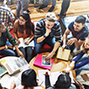 Thumbnail image of a group of young people at a table with books.