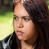 Teenage Indigenous Australian girl photographed outdoors.  She has a serious expression