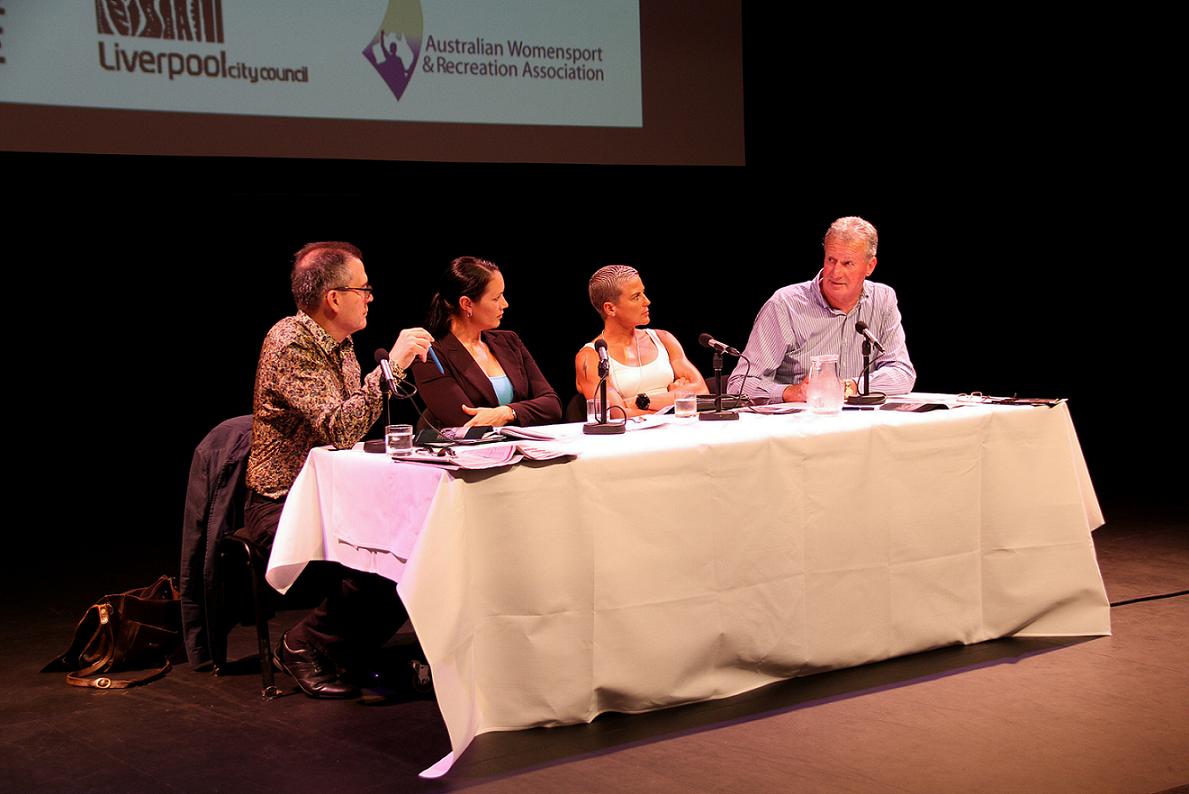 David Rowe sitting at a table with three other panelists, 2 women and 1 man.