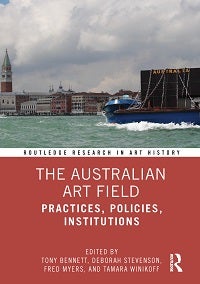 Cover of a book titled ‘The Australian Art Field’. On the top half of the cover is a photograph of Richard Bell’s sculptural protest ‘…no tin shack…’ on a barge in the Venice lagoon. Below the photograph is a thin white band with the words ‘Routledge Research in Art History’. The book title appears on the bottom half of the cover against a reddish background. It is ‘The Australian Art Field’. The subtitle is ‘Practices, Policies, Institutions’. Below the book title are the worlds ‘Edited by Tony Bennett, Deborah Stevenson, Fred Myers, and Tamara Winikoff’. The Routledge logo is in the lower right-hand corner of the cover.
