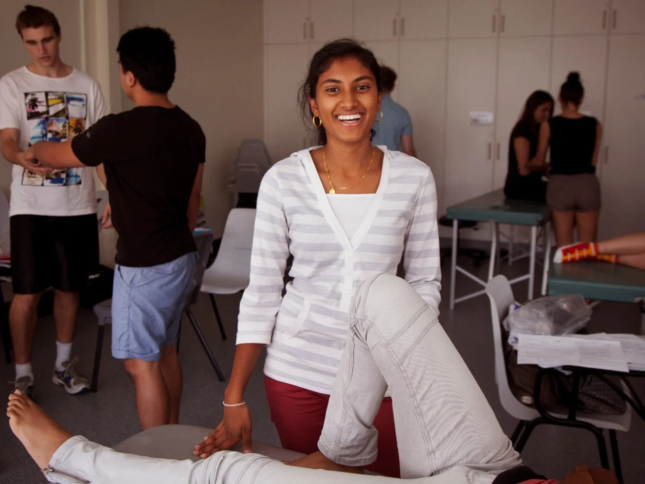 Female health support assistant providing direct client care to patient on bed