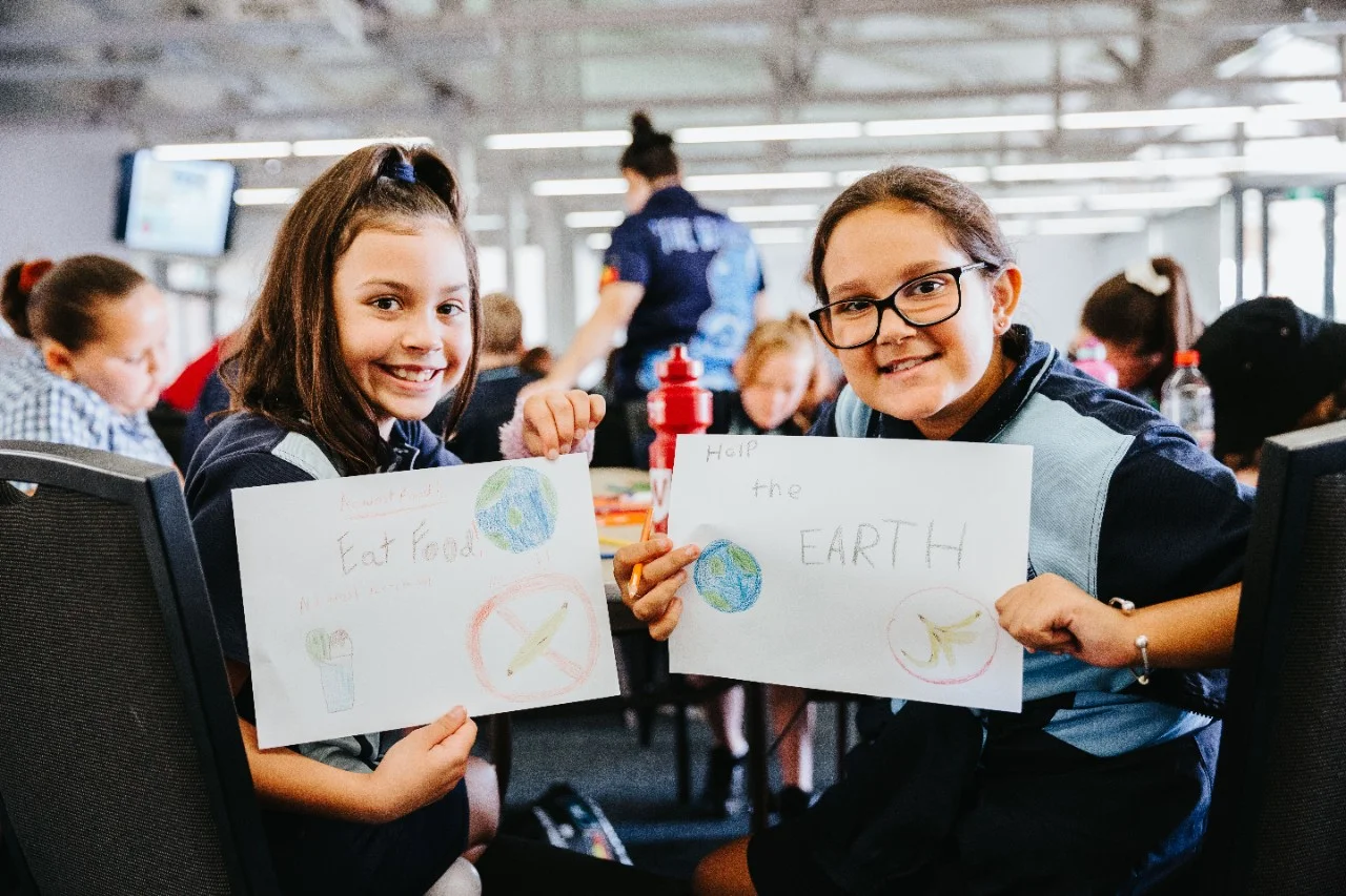 Two primary school students holding up drawings from the Heartbeat engagement program