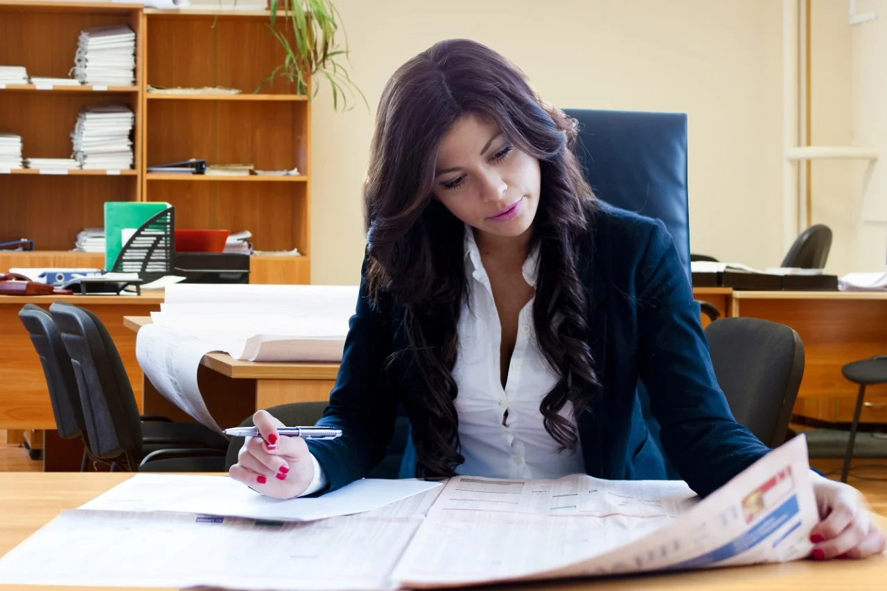 Female business administration professional reading newspaper