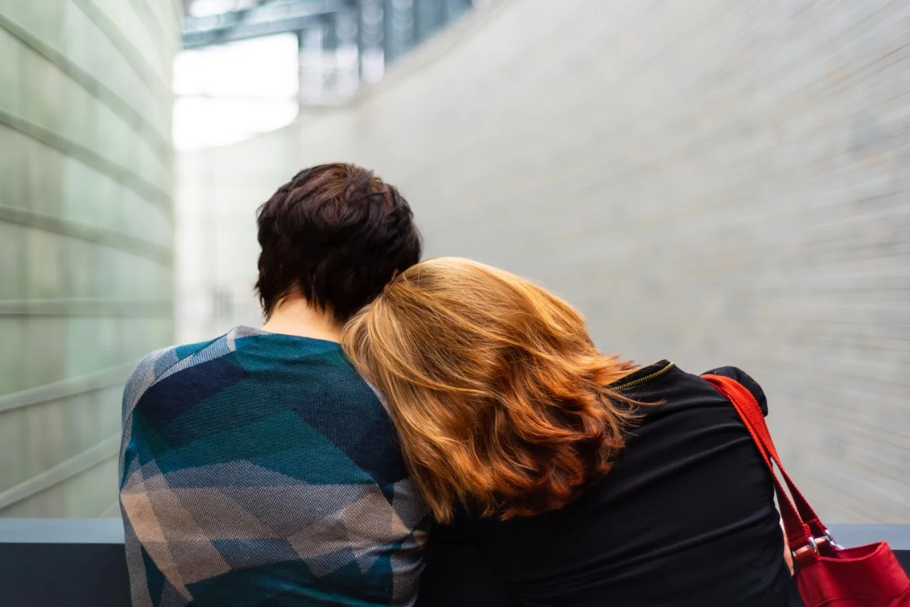 Female rests head on man's shoulder