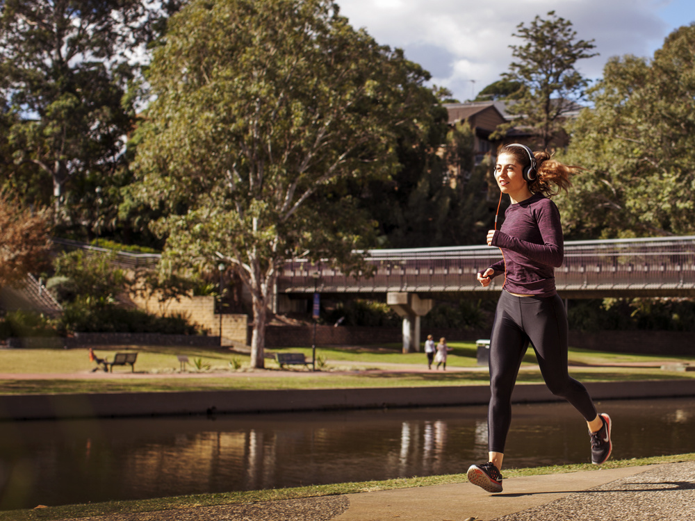 Woman running along bank of Parramatta River