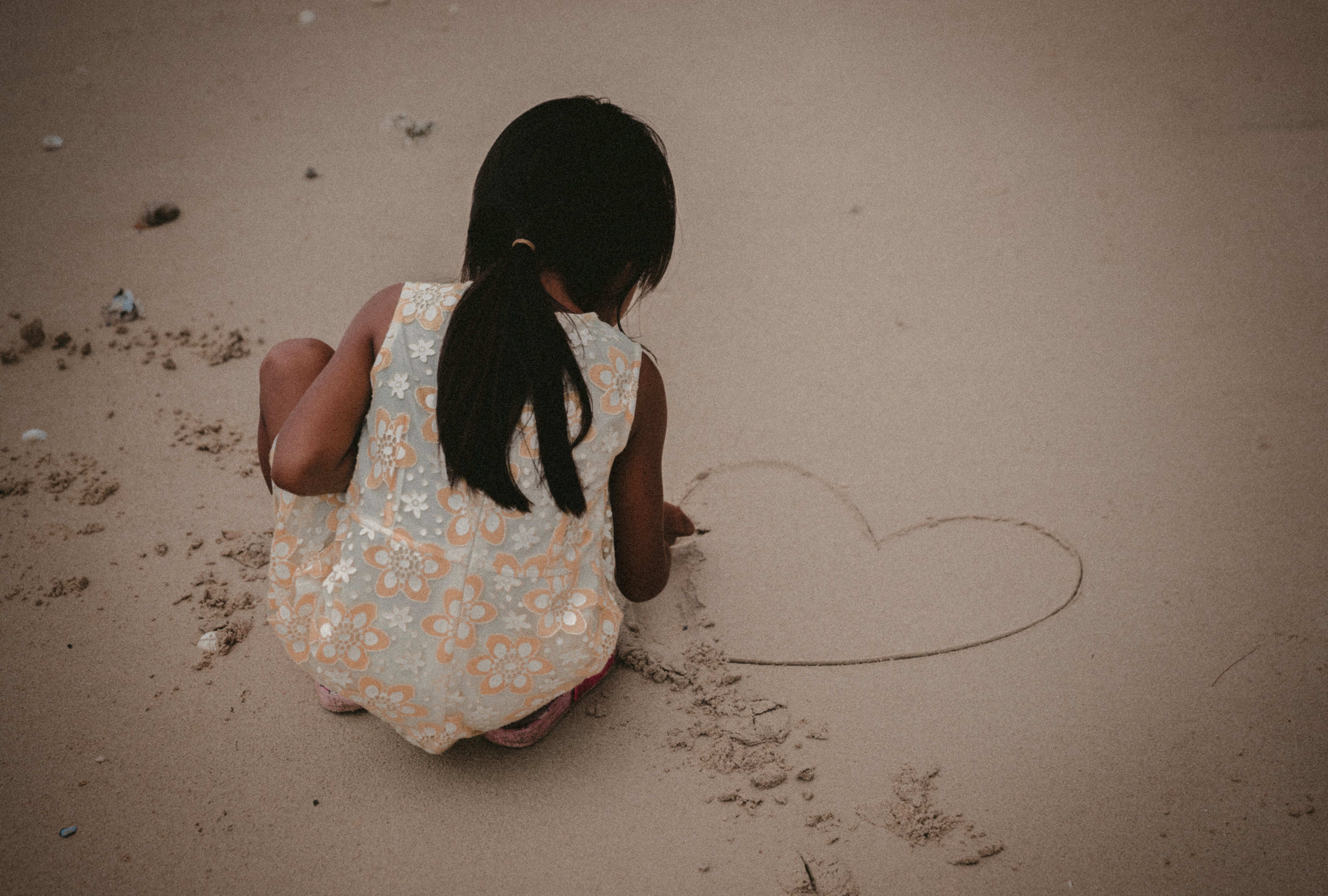 Young girl writing on the beach in Papua New Guinea