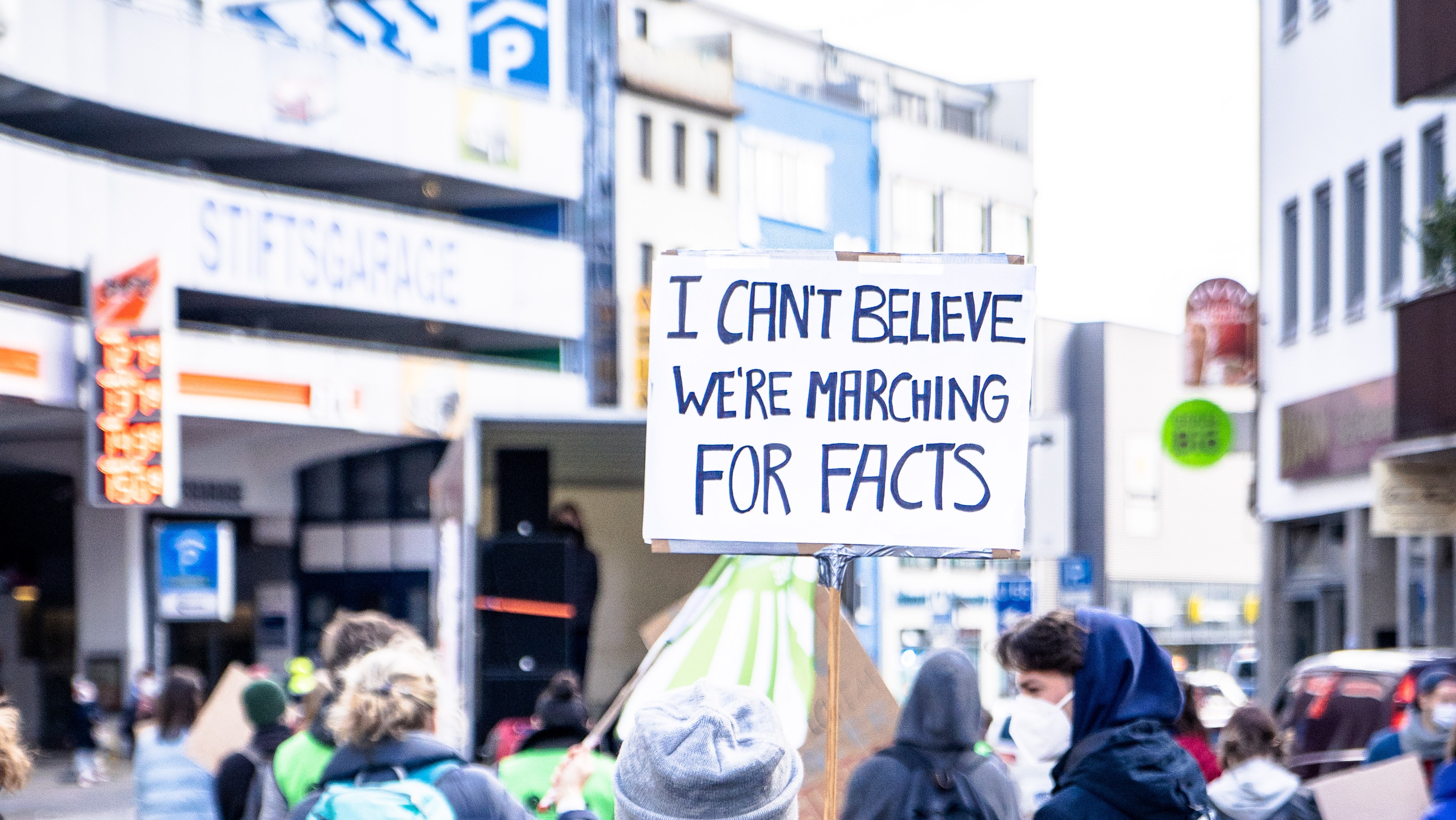 Protestor holds sign stating 'I can't believe we're marching for facts'