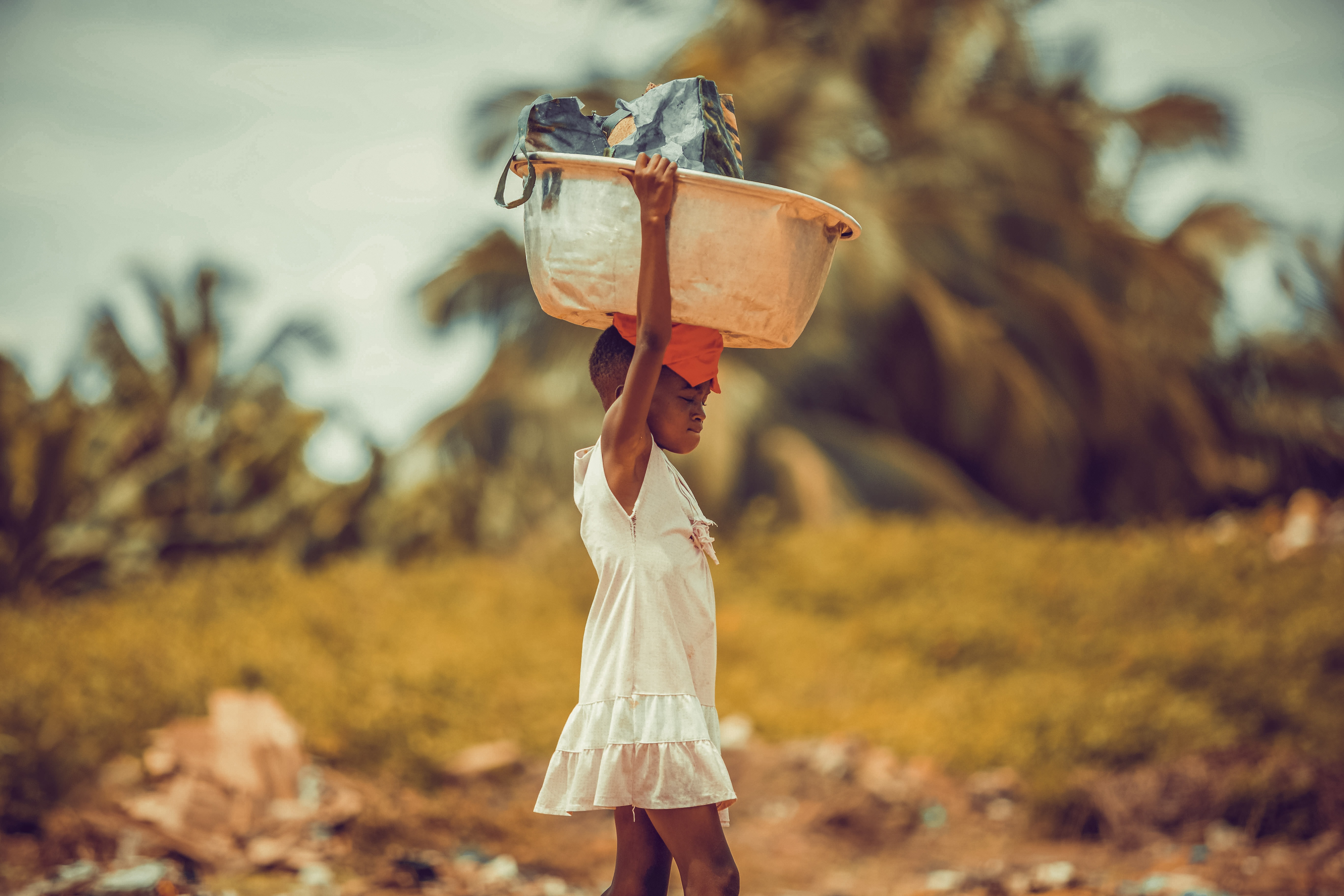 African child carrying basket on head