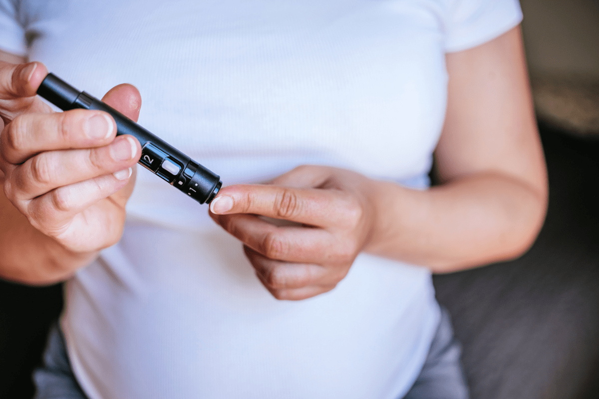 A pregnant woman testing blood sugar at home. 