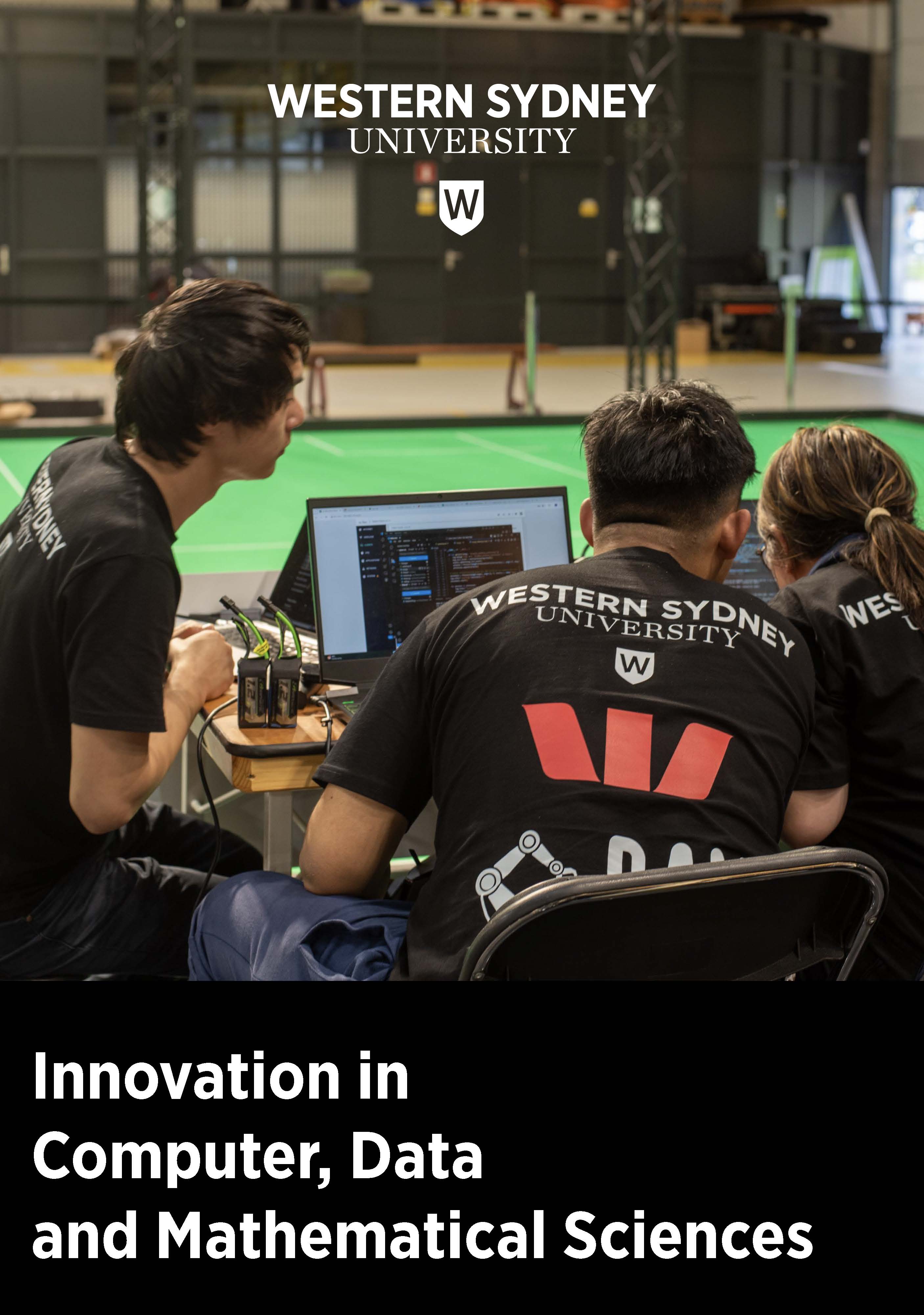 Computing students working behind laptop