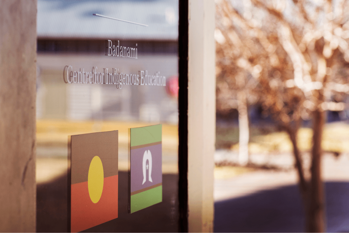 A door with the Badanami Centre for Indigenous Education logo with Aboriginal and Torres Strait Islander flags underneath it