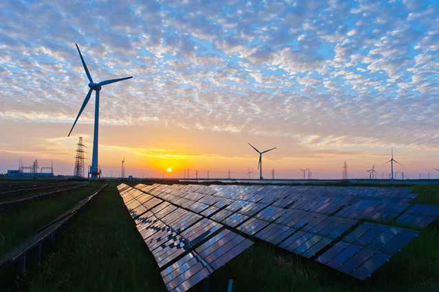Solar panels and wind turbines against sunrise