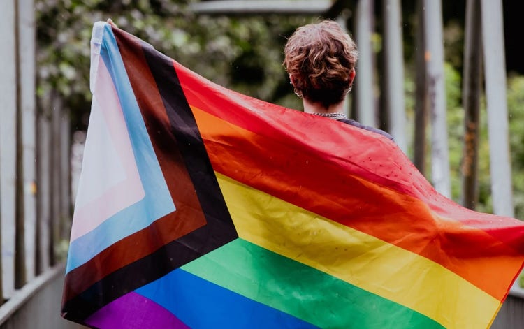 Photo of person holding progressive pride flag