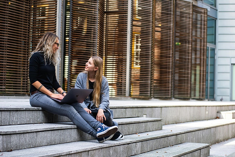 Two people talking on city steps