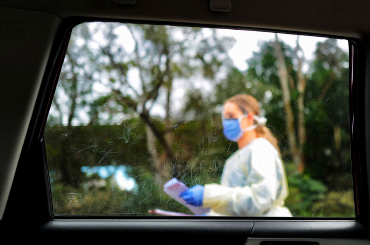 Healthcare worker seen through car window