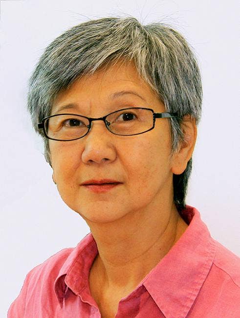 Close up of Aihwa wearing a pink shirt against a white background