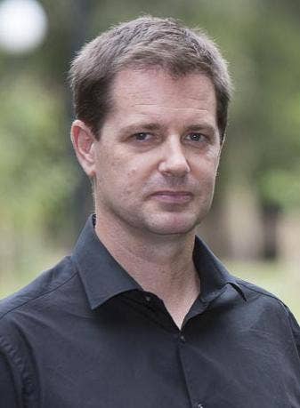 Should-up photo of Chris Gibson wearing a black collared shirt