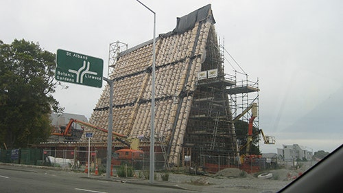 A church with an A-shaped roof is being built out of cardboard tubes.