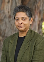 Dr Yasmin Tambiah with trees in the background.