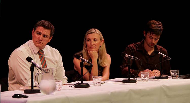 Keith sitting at a white table with two other panelllists, a man and woman