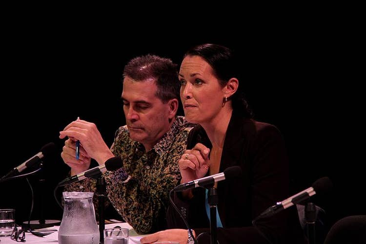 David Rowe sitting at a white table with Stephanie Brantz, with microphones