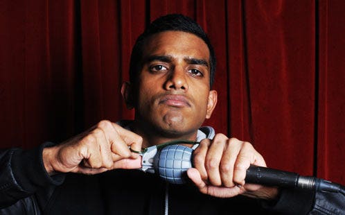 Ethnic man holding a microphone and fake grenade