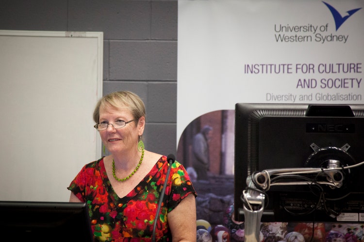 Katherine gibson standing behind lectern