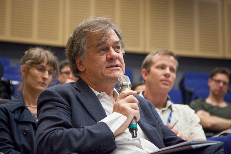 Tim holding microphone sitting down