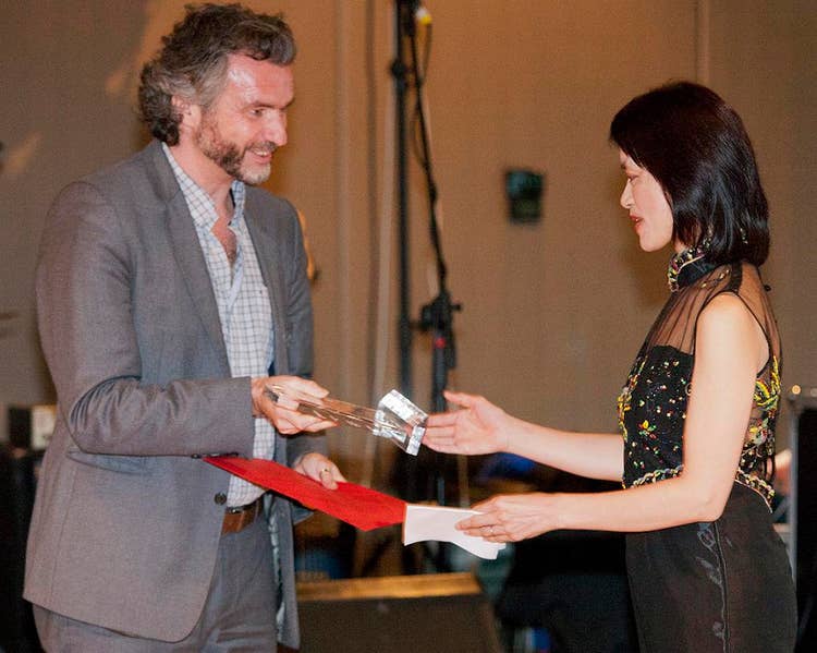 Adam presenting a glassed award to Xiaoying