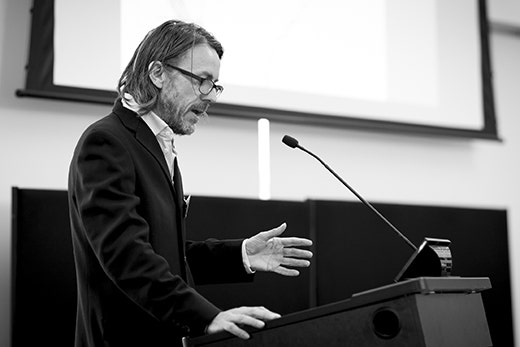 A black and white photo of Professor Donald McNeill presenting.