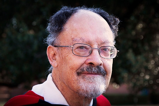 Close-up photo of Professor Bob Hodge from the shoulders upwards, wearing a graduation gown.