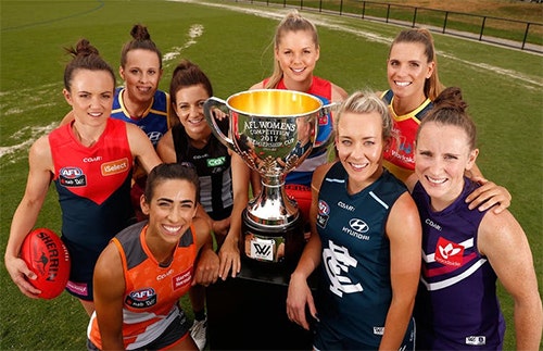 Players from the inaugural AFLW season with cup and ball.