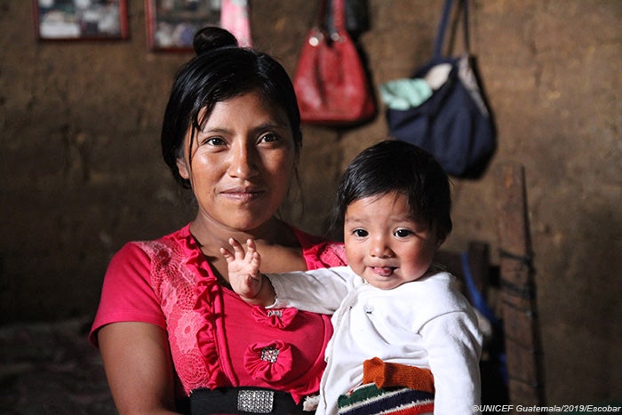 A mother, facing the camera, holds her baby. Photo ©UNICEF Guatemala/2019/Escobar.
