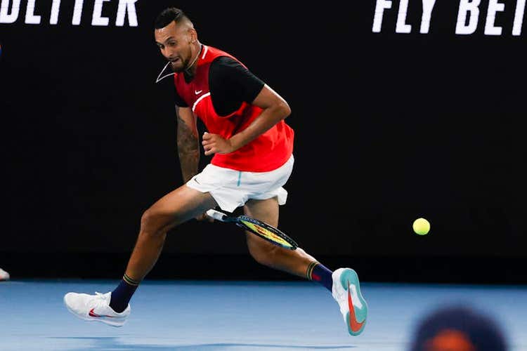 Nick Kyrgios plays a shot back between his legs.