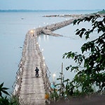 A motorcycle drives over the 1.5km bamboo bridge across the Mekong River.