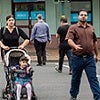 woman, man and young child crossing the street