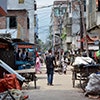 Thumbnail image of a young man walking through a street in a slum